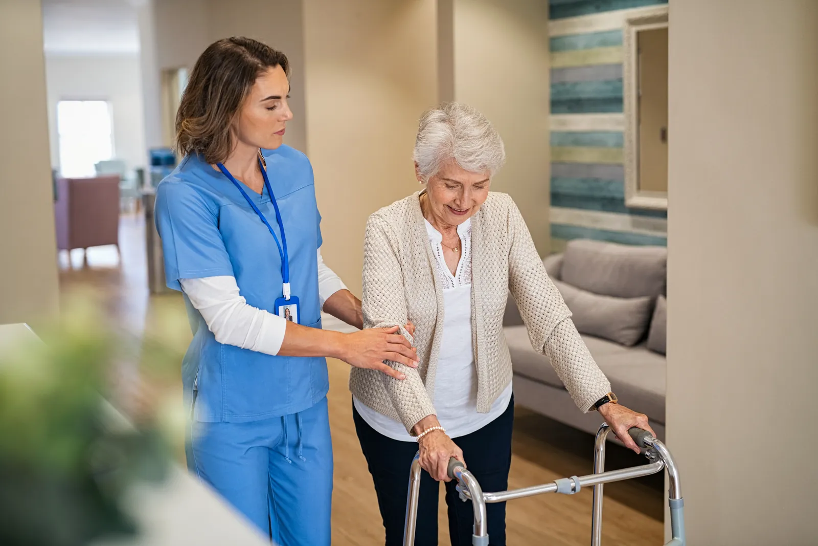 Care assistant helping a resident with her walking frame